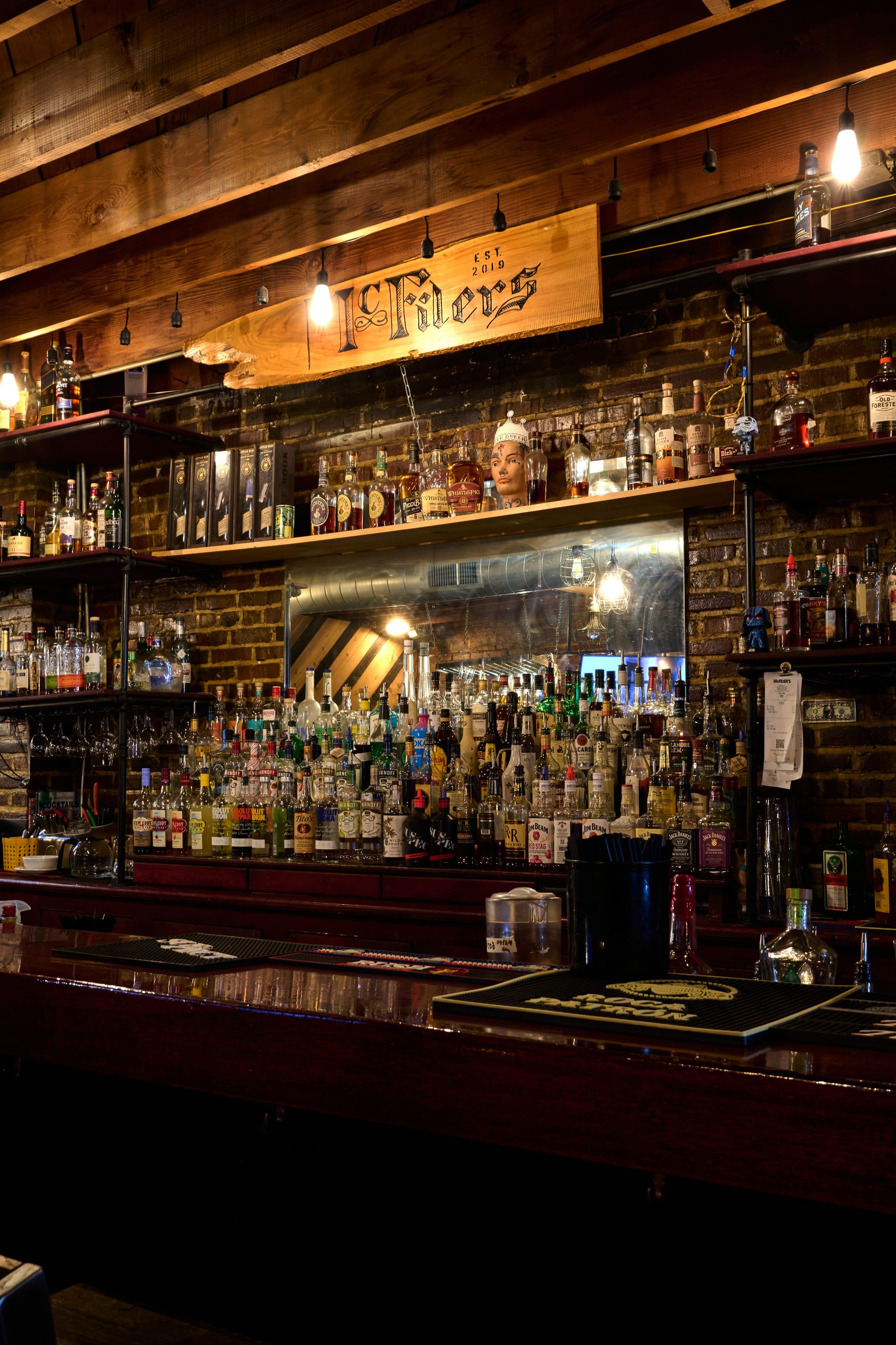 The McFiler's main bar in downtown Chehalis, WA: the carved 'McFilers Est 2019' sign over a 200+ bottle wall and polished bar top