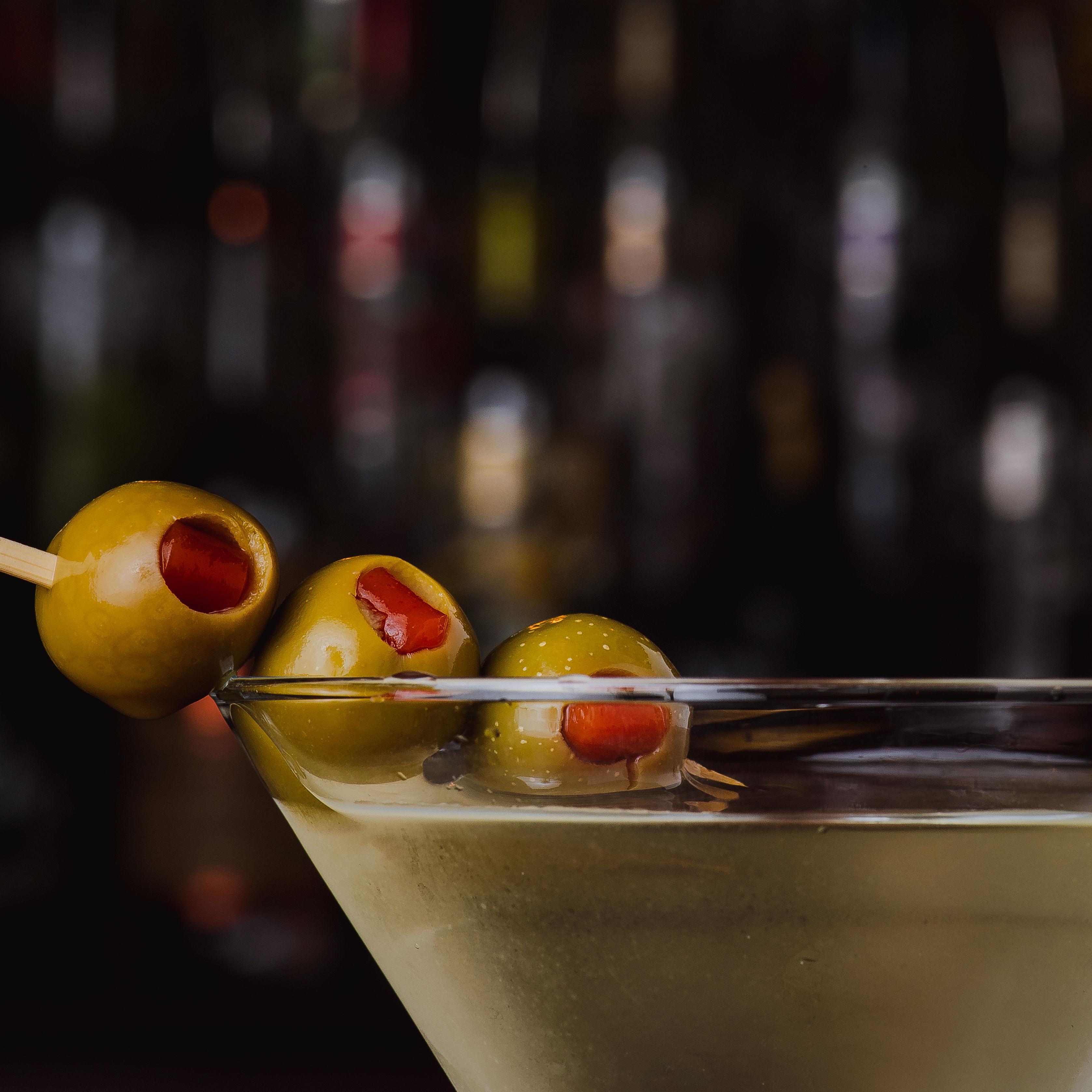 Three olives floating in a chilled martini